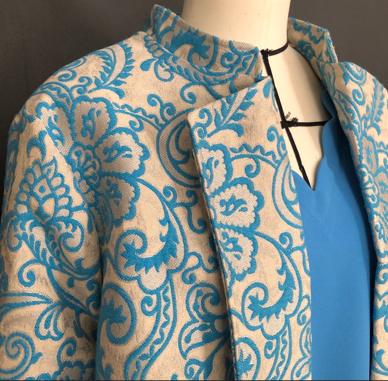 Manteau col mandarin, revers plaqués, manches poignets mousquetaire